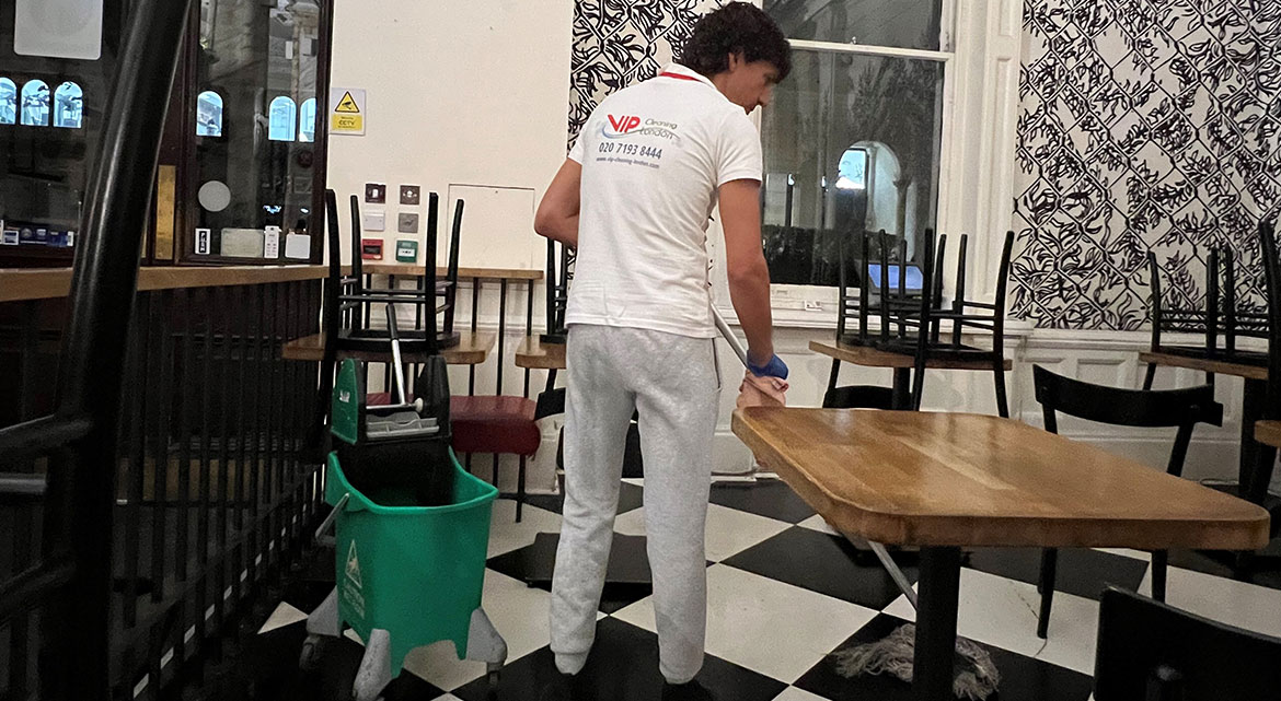 A cleaner from the team of VIP pub cleaning company cleans the floor.